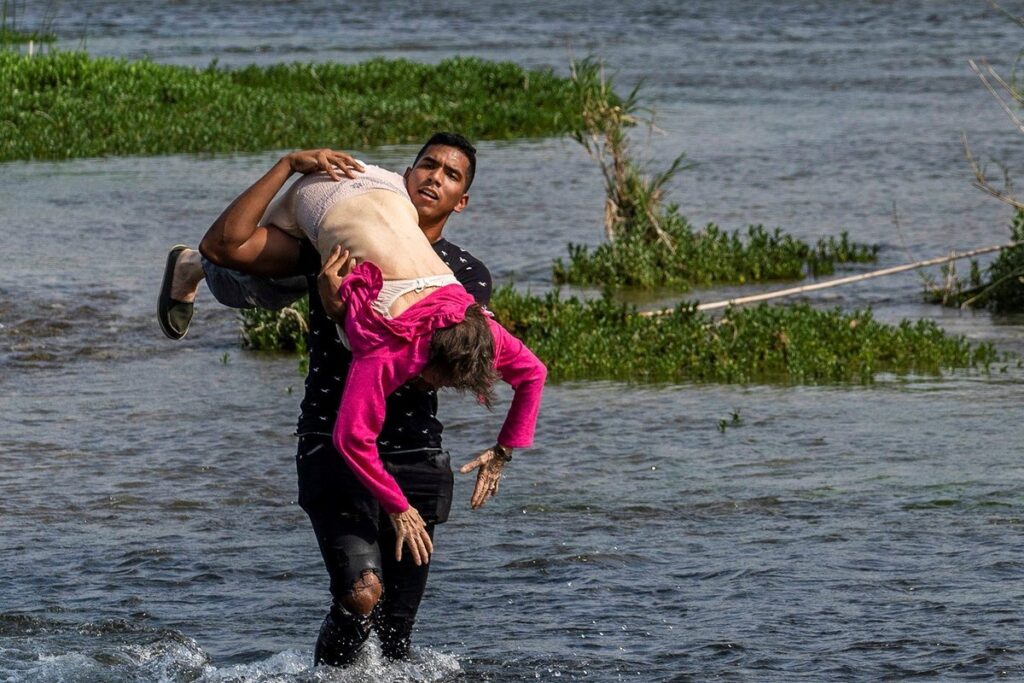 Migrante venezolano cruza en brazos el Río Bravo a una anciana (foto)